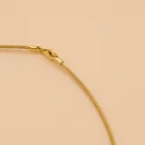 Gargantilla de diseño trenzado fino, elaborada en oro 9k, con acabado brillante y cierre seguro.