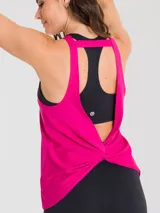 Remera deportiva sin mangas color fucsia, con cuello redondo y espalda estilo nadadora. Presenta un diseño holgado con un pequeño logo estampado en la parte inferior.