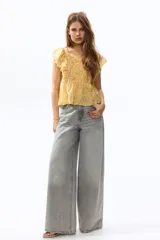 Top de algodón amarillo con estampado floreado, escote corazón, volados en los hombros y detalle de peplum en la cintura.