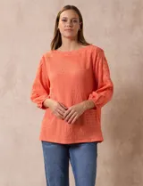 Blusa color salmón con textura arrugada, escote redondo con detalle de broderie, mangas 3/4 con puños elastizados y detalle de broderie en los hombros.