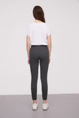 Calza negra de tiro alto con cierre lateral y detalle de costura en la rodilla.