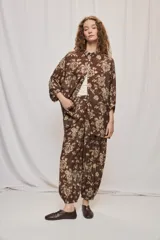 Camisa de silueta amplia y largo por debajo de la cadera, confeccionada en tela liviana con estampado floral en tonos marrón y tostado. Presenta cuello clásico, cierre frontal con botones y mangas tres cuartos.