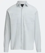 Camisa celeste de algodón, corte oversized, manga larga, cuello camisero, dos bolsillos frontales con solapa y cierre con botones.
