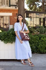 Sandalias bajas con base color suela, tiras anchas horizontales de cuero color marrón y plateado.