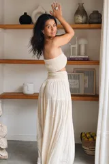 Conjunto compuesto por un top fruncido strapless de algodón con detalle de lurex y una falda larga fluida de talle alto con volantes y cintura fruncida.
