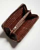 Billetera rectangular de cuero marrón con cierre perimetral y correa de muñeca. Presenta un diseño decorativo con costuras en forma de X en la parte frontal.