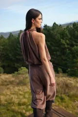 Blusa sin mangas de corte holgado con cuello alto tipo halter y pliegues frontales. Confeccionada en tela con textura sutil.