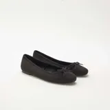 Bailarinas de mujer en color negro, confeccionadas en material tipo antelina con acabado suave. Presentan un diseño clásico de punta redondeada y un pequeño lazo decorativo en la parte frontal.