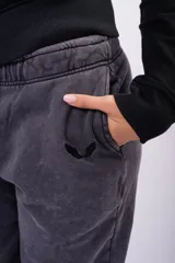 Pantalón de jogging color gris oscuro con efecto lavado, confeccionado en frizza. Presenta cintura elástica con cordón de ajuste y corte relajado.