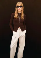 Cardigan de punto fino color marrón chocolate, con diseño entallado, cuello redondo y cierre frontal completo con botones pequeños. Presenta textura acanalada y mangas largas.