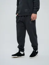 Pantalón jogger celeste de felpa, con cintura elástica ajustable con cordón, puños elastizados en los tobillos y un parche con el logo de la marca en la pierna izquierda.