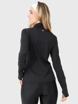 Buzo deportivo de manga larga en color negro, confeccionado en tela técnica suave y delgada. Presenta un diseño con medio cierre frontal, cuello alto y aberturas para los pulgares en los puños.
