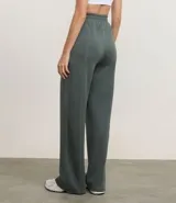 Pantalón deportivo femenino color verde oscuro, confeccionado en modal, con corte recto y largo. Presenta cintura elástica y detalle de trenzadora en la parte delantera.