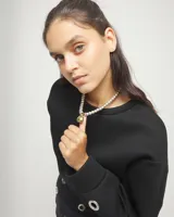 Collar compuesto por una cadena de esferas medianas bañadas en plata de ley, con una esfera grande central bañada en oro de 18k. Incluye cierre de mosquetón y cadena de alargue con placa distintiva de la marca.