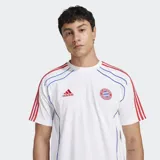 Remera deportiva Adidas de manga corta, color blanco, con cuello redondo acanalado. Presenta el escudo del FC Bayern bordado en el pecho izquierdo y detalles de ribetes en azul y rojo que recorren el torso y los hombros, donde se aprecian las tres franjas rojas características de la marca.