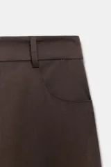 Pantalón de tiro alto con diseño tipo balloon, cintura con trabillas, bolsillos laterales y cierre frontal con cremallera y botón.