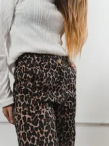 Pantalón de corte recto con estampado animal print de leopardo. Cuenta con bolsillos traseros y una etiqueta de cuero con el logo de la marca en uno de ellos.
