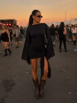 Vestido corto negro de manga larga acampanada, con diseño ajustado al cuerpo y detalle de nudo lateral con caída asimétrica.