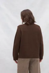 Cárdigan color crema de tejido de punto industrial con escote en V, combinación de puntos y botones decorativos en las mangas.