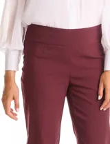 Pantalón de corte entallado y largo cropped, confeccionado en tejido con elasticidad técnica resistente a las arrugas. Presenta una pretina ancha y plana para un ajuste cómodo, bolsillos simulados en el frente y en la parte posterior, y pequeñas aberturas laterales en el ruedo.