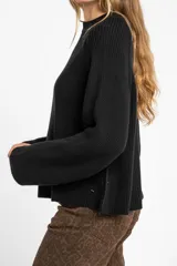 Sweater de algodón color azul, de punto grueso, con cuello redondo y mangas largas.