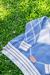 Saco tejido de punto con diseño de rombos en color bordó y naranja, con detalles en lurex. Presenta cuello redondo, cierre frontal con botones y mangas abullonadas con puños acanalados.