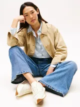 Zapatillas de piel napa color blanco con detalles en beige y suela de goma color caramelo. Presentan un diseño de corte bajo con cordones, insignia metálica del monograma TH en el lateral y logo de Tommy Hilfiger en relieve en la lengüeta.