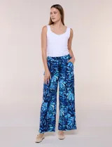 Pantalón de poliéster de corte ancho tipo palazzo y calce relajado, con estampado de hojas en tonos azules, cintura alta elastizada con cordón ajustable y bolsillos laterales.