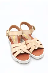 Sandalia de cuero color beige, con tiras cruzadas y hebilla.