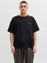 Remera negra de corte holgado, con mangas cortas y un pequeño estampado tipográfico en el pecho a la altura del corazón.