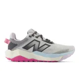 Championes de trail running New Balance modelo Nitrel V6, con diseño en tonos gris, lila, celeste y suela fucsia. Presentan tecnología AT Tread en la suela para mayor tracción y refuerzo Toe Protect en la puntera.