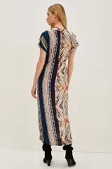 Vestido midi de viscosa con estampado étnico multicolor, escote en V, mangas cortas y ajuste con cordón en la cintura. Presenta una abertura frontal en la falda.