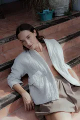 Chaqueta acolchada de algodón en color crudo, con diseño de matelassé, corte holgado, mangas largas y bolsillos frontales tipo parche.