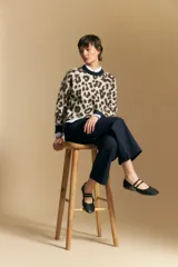 Sweater de tejido jacquard con estampado animal print, de silueta relajada y manga larga. Presenta cuello redondo y bordes en contraste de color bordó.
