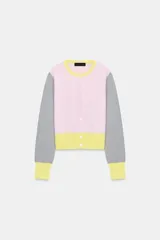 Chaqueta de punto con diseño color block, cuello redondo y manga larga. Presenta cuerpo en color rosado con franja inferior amarilla, mangas grises con puños amarillos y cierre frontal con botones.