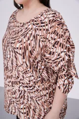 Blusa estampada con cuello redondo y mangas cortas con aberturas y lazos.