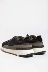 Zapatillas deportivas color crema con detalles en beige, negro y blanco.