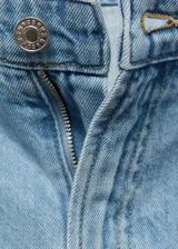Short de denim estilo vaquero, color celeste, de tiro medio con diseño recto, pinzas en el frente y trabillas para cinturón. Cuenta con dos bolsillos laterales y dos bolsillos en la parte posterior.