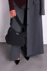 Bolso de nylon color naranja quemado, con textura sutil y manija fruncida. Presenta un parche rectangular negro con el logo 'KUL.' en blanco en el frente.