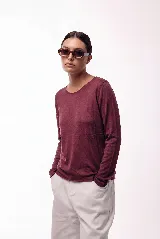 Remera de manga larga con cuello redondo, confeccionada en una mezcla de fibras naturales. Presenta un diseño básico y versátil, ideal para usar como prenda principal o como capa base.