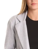 Blazer de tejido soft color beige, con silueta relajada y corte largo. Presenta cuello con solapas muesca, frente abierto sin botones y dos bolsillos de parche frontales.