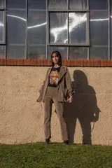 Chaqueta de crepé elastizado de lurex oro viejo, con corte clásico y cierre frontal con botones.