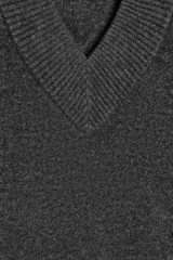 Jersey de punto color gris oscuro, con cuello pico y manga larga. Los acabados son en rib.