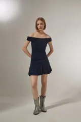 Vestido corto azul marino con escote strapless, diseño al cuerpo con frunces en el torso y falda con volados en el ruedo.