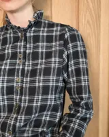 Camisa de algodón con estampado de rayas verticales finas, cuello alto con volados, cierre frontal con botones dobles y mangas largas con puños elásticos terminados en volados.