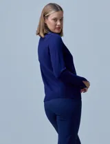 Polera de tejido fino, color rosado, con cuello alto, manga larga y detalle de tajo en los puños.