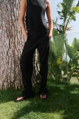 Pantalón de lino y rayón color negro, con corte holgado, cintura elástica en la parte trasera y bolsillos delanteros. Presenta lazos ajustables en la botamanga.