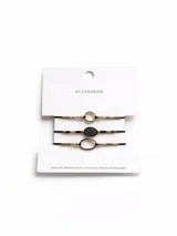 Set de tres pulseras con hilo negro y cuentas doradas. Dos pulseras tienen un dije ovalado con centro transparente y la pulsera restante tiene un dije ovalado con centro negro y diseño de hoja.