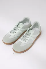 Zapatillas Adidas Samba color verde claro con detalles en blanco y suela de goma color caramelo.