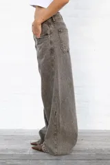 Jean de mujer color gris oscuro con efecto acid wash, de corte holgado y tiro bajo.